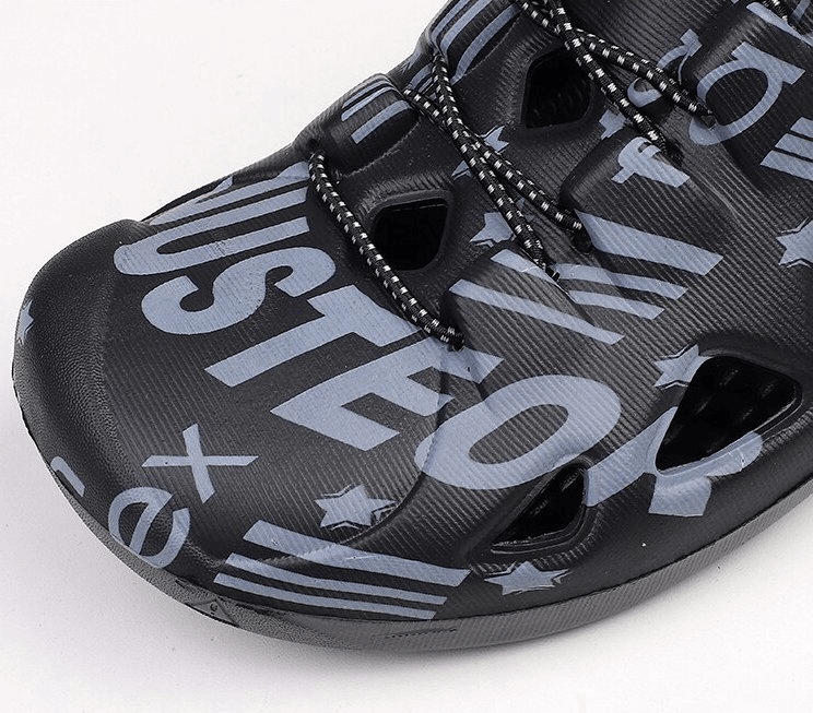 Close-up of stylish men's lightweight quick dry black clog with EVA material and bold letters, perfect for casual beach wear.